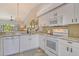 Bright kitchen featuring white cabinets, modern appliances, granite countertops, and an open view to the living area at 9540 High Gate Dr # 1422, Sarasota, FL 34238