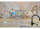 Open-concept living room with stylish chandelier, comfortable seating, and a view to the outdoor balcony at 9540 High Gate Dr # 1422, Sarasota, FL 34238