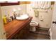 Cozy bathroom featuring a solid wood vanity and cabinet, tiled walls, and wood-look vinyl flooring at 1099 6Th Ne Ave, Largo, FL 33770
