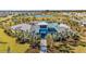 Aerial view of the community clubhouse with a pool, surrounded by lush landscaping and palm trees at 12051 Lansing Gln, Parrish, FL 34219