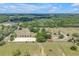 Expansive aerial view of the property with horse arena, pastures, and surrounding trees at 12714 Tyler Run Ave, Odessa, FL 33556