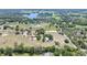 Expansive aerial view showcases the property's layout, including fields, homes, roads, and a pond at 12714 Tyler Run Ave, Odessa, FL 33556