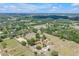 Aerial view of country land featuring paddocks, multiple residences with red roofs and verdant trees at 12714 Tyler Run Ave, Odessa, FL 33556