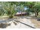 Exterior view of a red-roofed horse barn, surrounded by mature trees providing a rustic setting at 12714 Tyler Run Ave, Odessa, FL 33556