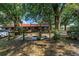 Exterior shot of a barn with stalls, nestled among mature trees and landscaping, showing the charm of rural living at 12714 Tyler Run Ave, Odessa, FL 33556