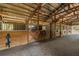 Spacious horse barn interior with multiple stalls and wooden construction, providing a comfortable animal shelter at 12714 Tyler Run Ave, Odessa, FL 33556