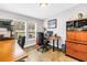 This home office features wood-style floors, large windows providing natural light, and multiple work stations at 12714 Tyler Run Ave, Odessa, FL 33556