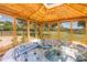 Relaxing hot tub inside a wood gazebo with views of the horse pasture and surrounding greenery at 12714 Tyler Run Ave, Odessa, FL 33556