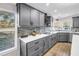 Modern kitchen with gray cabinets, quartz countertops, and stainless steel appliances at 12714 Tyler Run Ave, Odessa, FL 33556