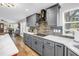 Well-lit kitchen with gray cabinets, stainless steel hood, and modern countertop at 12714 Tyler Run Ave, Odessa, FL 33556