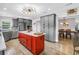 Open kitchen with a red island, modern lighting, and stainless steel appliances at 12714 Tyler Run Ave, Odessa, FL 33556