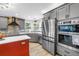 Stylish kitchen featuring stainless steel appliances, gray cabinets, and modern finishes at 12714 Tyler Run Ave, Odessa, FL 33556