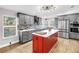 Bright kitchen with gray cabinets, modern appliances, and a red kitchen island at 12714 Tyler Run Ave, Odessa, FL 33556