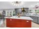 Kitchen with a red island, gray cabinets, and stone backsplash, flooded with natural light at 12714 Tyler Run Ave, Odessa, FL 33556