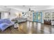 Bright living room with hardwood floors, a gray sofa, ceiling fan, and turquoise doors with beautiful outdoor views at 12714 Tyler Run Ave, Odessa, FL 33556