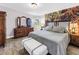 A primary bedroom with a large bed, decorative wall art, a bay window with views of the outdoors, and wood-style flooring at 12714 Tyler Run Ave, Odessa, FL 33556