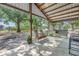 Picturesque outdoor patio with wooden chairs, porch swing, and views of the surrounding trees and landscape at 12714 Tyler Run Ave, Odessa, FL 33556