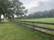 A lush green pasture enclosed with a wooden fence is perfect for livestock or recreation at 12714 Tyler Run Ave, Odessa, FL 33556
