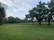 Spacious green pasture enclosed by a dark wooden fence, perfect for horses or livestock at 12714 Tyler Run Ave, Odessa, FL 33556