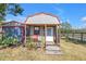 Exterior view of a charming shed with a porch and red accents, perfect for a cozy workspace or storage at 12714 Tyler Run Ave, Odessa, FL 33556