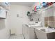 Well-lit laundry room featuring modern appliances, storage shelves, and a utility sink at 139 Adair Ave, Sarasota, FL 34243