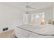 Bright bedroom features a bed with crisp white linens, carpet flooring, and open doorway to another room at 139 Adair Ave, Sarasota, FL 34243
