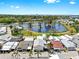 Aerial view of a charming neighborhood featuring a large pond and lush landscaping with a waterfront in the distance at 14 Braden Castle Dr, Bradenton, FL 34208
