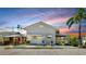 Charming home exterior with a light color, palm trees, and a cozy seating area at 14 Braden Castle Dr, Bradenton, FL 34208