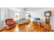 Living room featuring hardwood floors, ceiling fan, and comfortable seating with a TV and grand father clock at 14 Braden Castle Dr, Bradenton, FL 34208