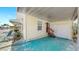 Covered patio with a painted floor, offering a view of the neighborhood and access to the garage, ideal for outdoor living at 14 Braden Castle Dr, Bradenton, FL 34208
