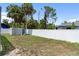 Backyard features white vinyl fence, grass, and trees at 16834 Toledo Blade Blvd, Port Charlotte, FL 33954