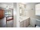 Bathroom with a single sink vanity, toilet, and mirror, adjacent to the bedroom at 16834 Toledo Blade Blvd, Port Charlotte, FL 33954