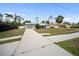 A single story home has a long driveway and gray paint with a green yard at 16834 Toledo Blade Blvd, Port Charlotte, FL 33954