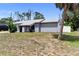 Charming gray single-story home featuring a well-maintained lawn and a welcoming entrance with black accents at 16834 Toledo Blade Blvd, Port Charlotte, FL 33954
