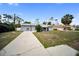 A single story home has a long driveway and gray paint with green yard at 16834 Toledo Blade Blvd, Port Charlotte, FL 33954
