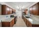 Galley kitchen featuring granite countertops, stainless steel appliances, and dark wood cabinets at 16834 Toledo Blade Blvd, Port Charlotte, FL 33954