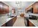 Galley kitchen with granite counters, stainless appliances, dark cabinets, and tile floor at 16834 Toledo Blade Blvd, Port Charlotte, FL 33954