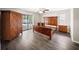 Spacious bedroom with wood-look floors, ceiling fan, and sliding glass doors to the pool area at 16834 Toledo Blade Blvd, Port Charlotte, FL 33954