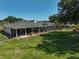 Spacious backyard with a screened-in patio, manicured lawn, and mature trees, ideal for relaxation and outdoor gatherings at 16918 Waterline Rd, Bradenton, FL 34212