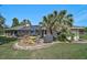Backyard features a screened lanai and patio seating surrounded by a well-maintained yard with a palm tree at 16918 Waterline Rd, Bradenton, FL 34212