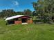 Exterior view of a well-maintained barn with a metal roof, providing ample covered space at 16918 Waterline Rd, Bradenton, FL 34212