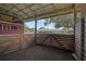 View from inside the barn showing the horse stalls and the view of the backyard beyond at 16918 Waterline Rd, Bradenton, FL 34212