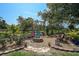 Landscaped backyard fire pit area with seating, garden, and mature trees at 16918 Waterline Rd, Bradenton, FL 34212