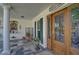 Covered front porch featuring tile flooring and a decorative wooden front door at 16918 Waterline Rd, Bradenton, FL 34212