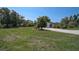 A view of the home with a circular driveway, mature trees, and landscaping at 16918 Waterline Rd, Bradenton, FL 34212