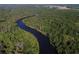 Stunning aerial perspective of a river meandering through a dense, vibrant forest in a picturesque landscape at 16943 Rosedown Gln, Parrish, FL 34219