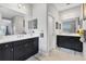 Bathroom featuring double vanity with black cabinets, tile flooring, and white walls at 16943 Rosedown Gln, Parrish, FL 34219