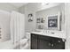 Bathroom featuring a white shower curtain, black vanity, and modern fixtures at 16943 Rosedown Gln, Parrish, FL 34219