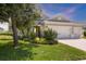 Charming single-story home showcasing lush landscaping, a well-manicured lawn, and an inviting three-car garage at 16943 Rosedown Gln, Parrish, FL 34219