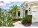 Charming home exterior featuring a well-manicured lawn, tropical landscaping, and a walkway to the front door at 16943 Rosedown Gln, Parrish, FL 34219